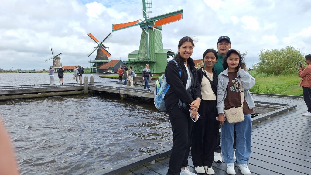 Students taking photos by seaside windmill in Amsterdam during Evergreen Tours Europe Educational Tour